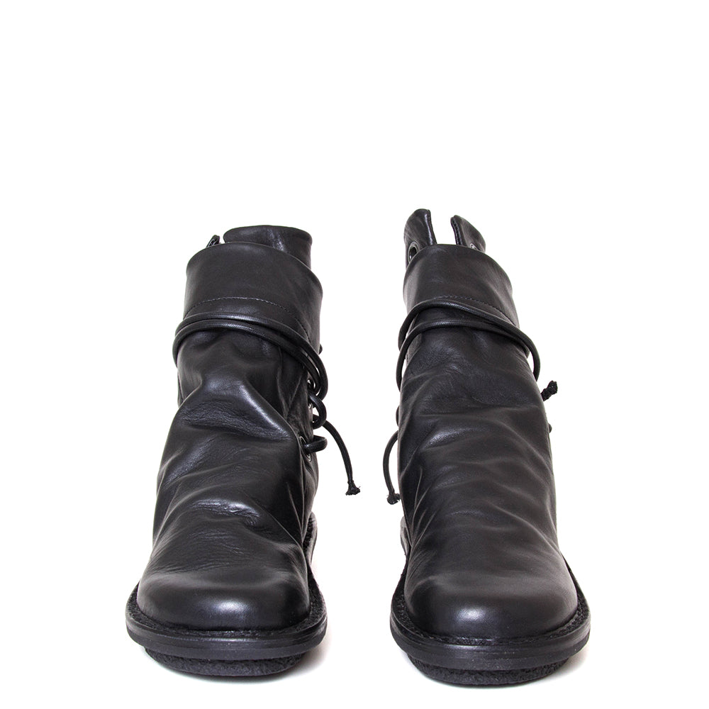 Trippen Awning. Women's leather slip-on, ankle boot in black leather, wrap-around laces. Made in Germany. Front view.