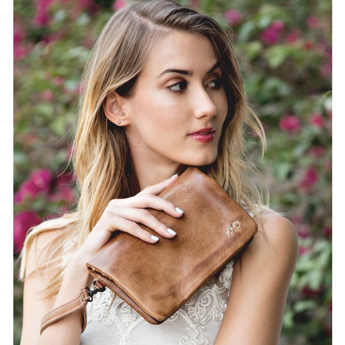 Bed Stu Cadence Wallet, Clutch and Crossbody Women's bag, purse in natural white leather. Worn view, being hold by the small leather loop.